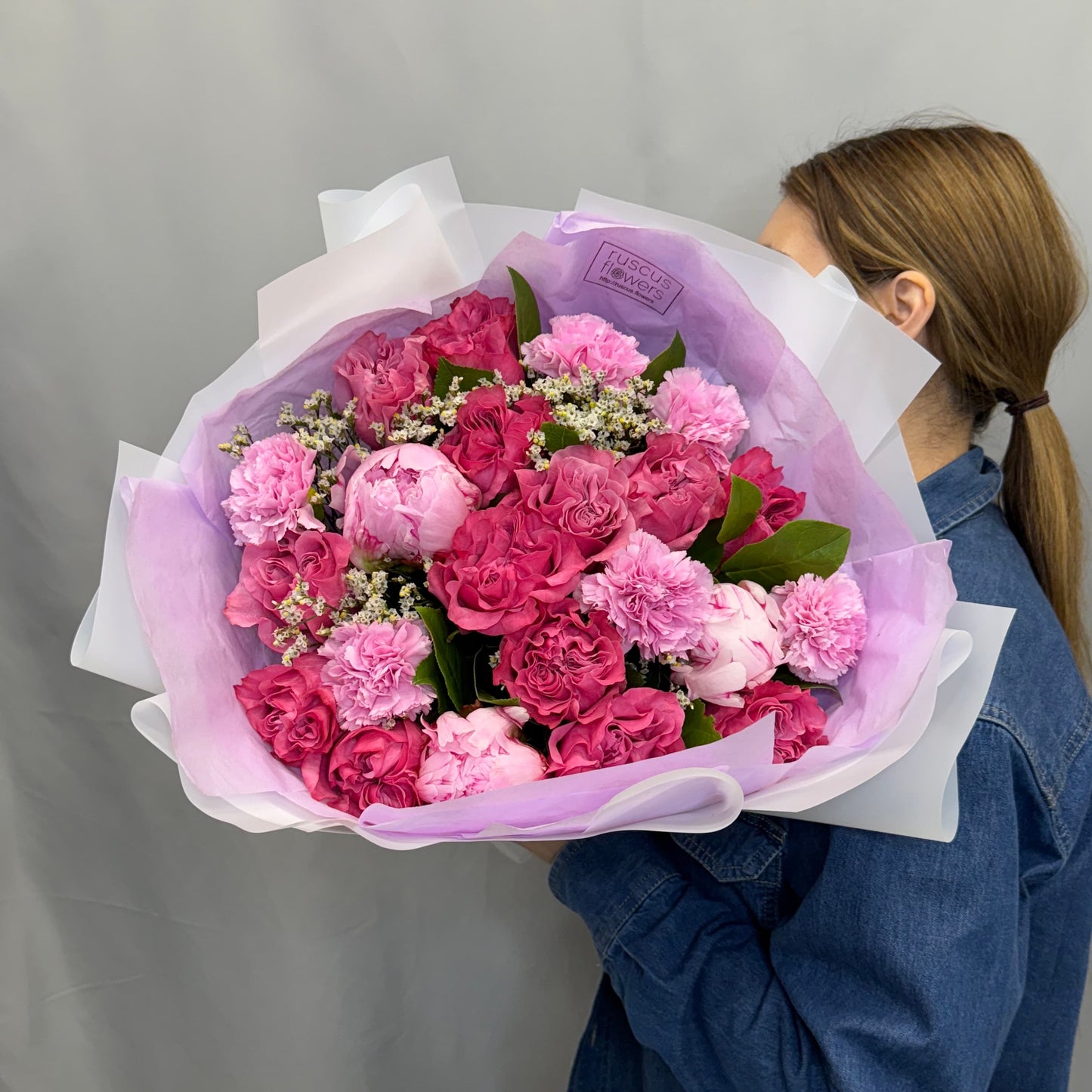 Colorful bouquet with roses, peonies, carnations, and seasonal greenery