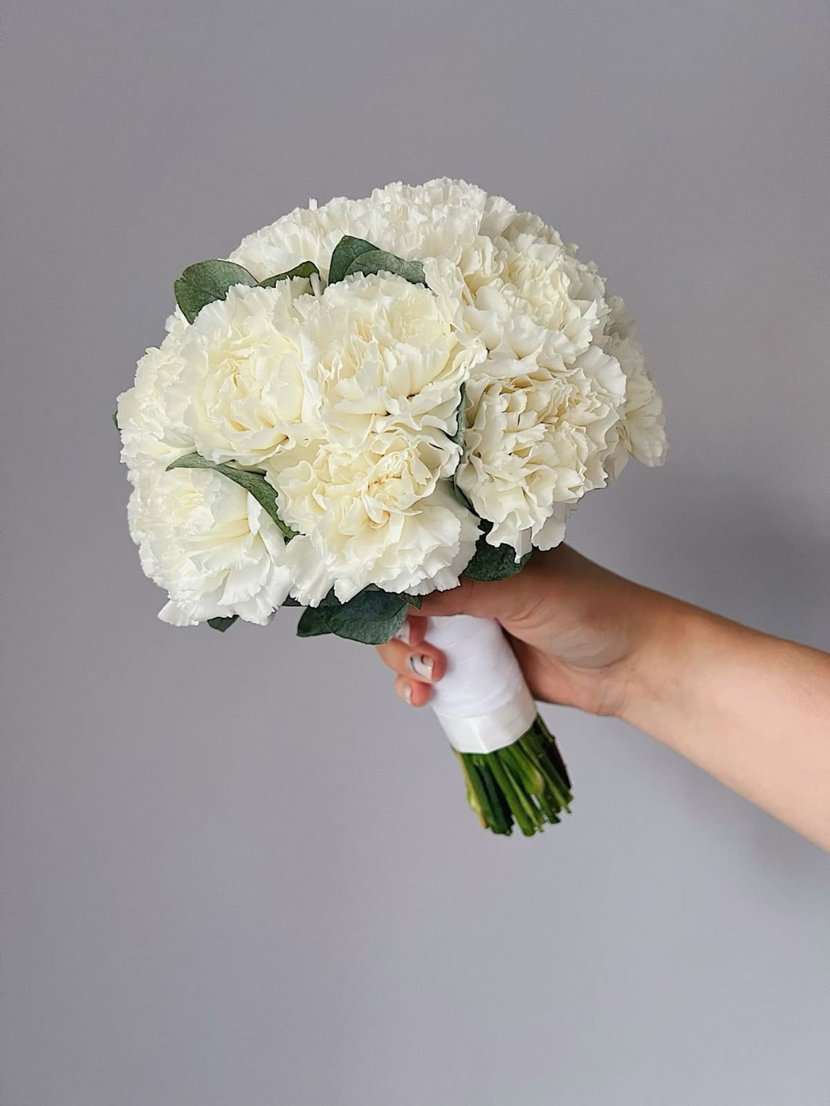 Round white bridal bouquet made of dianthus flowers.