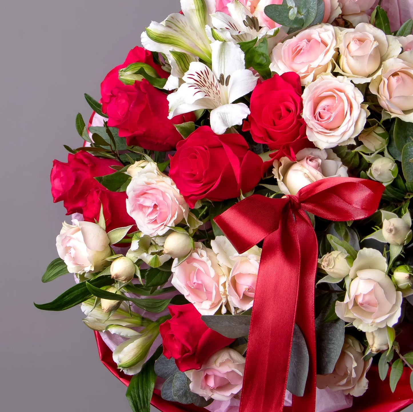 Close-up of bright roses and spray roses in floral arrangement