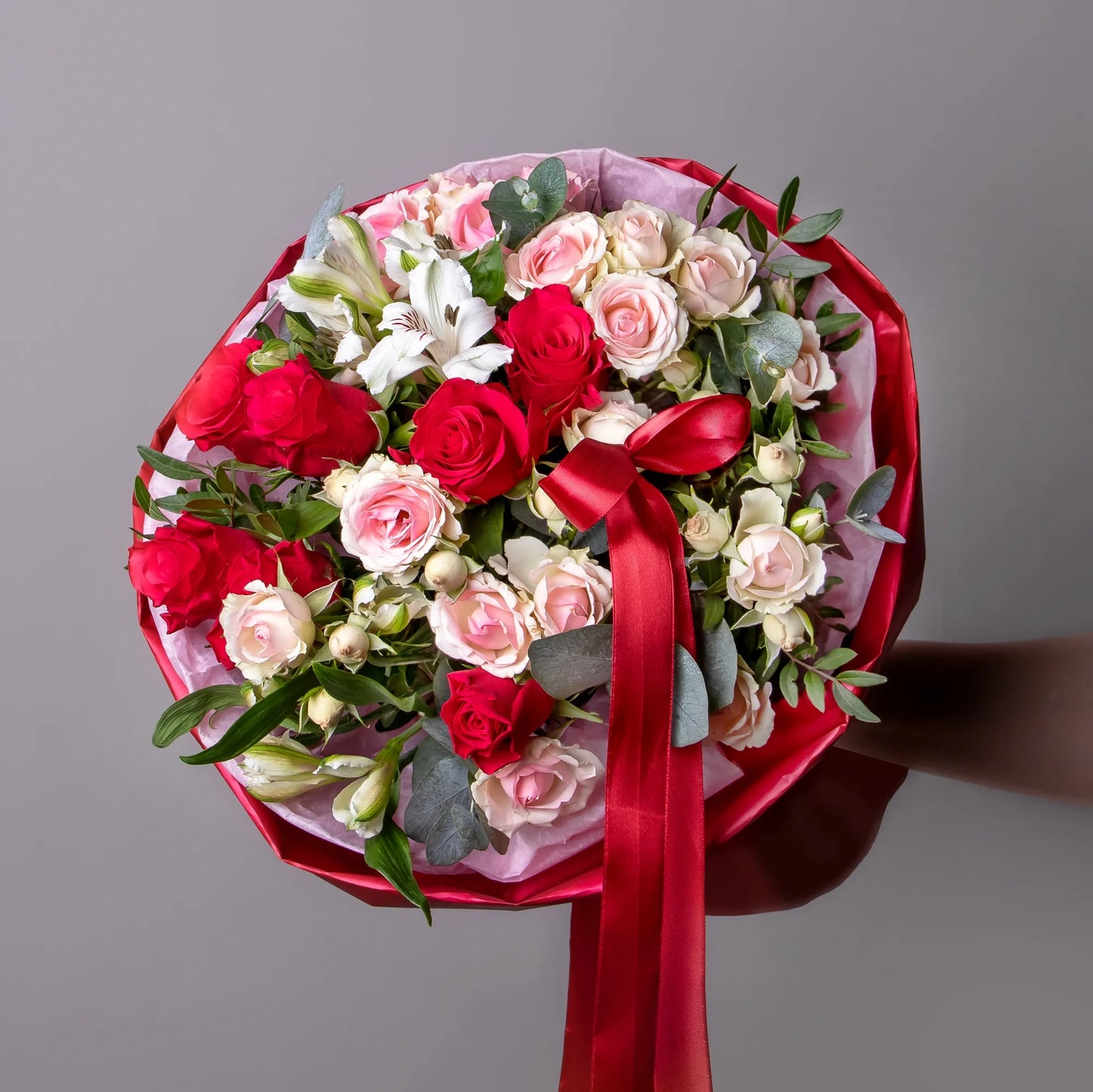 Bright rose and spray rose bouquet with eucalyptus and pistachio leaves