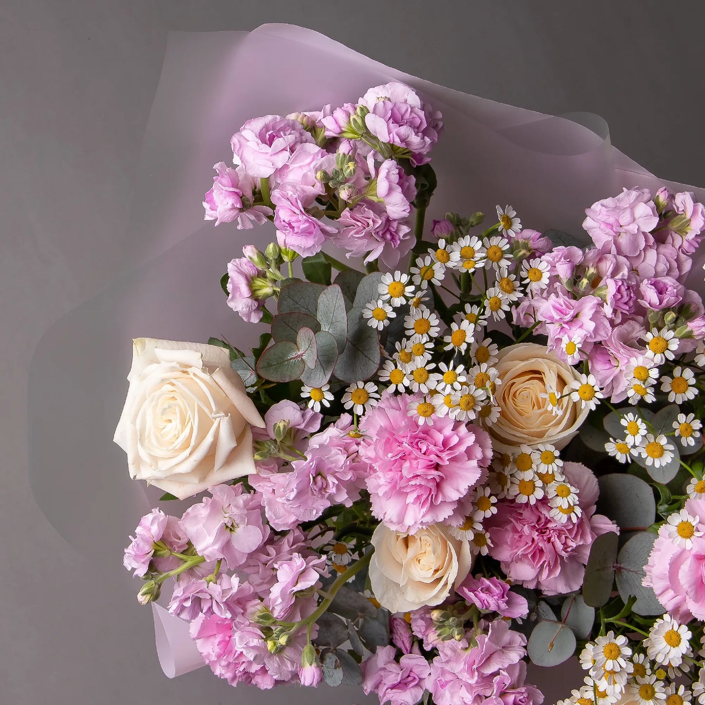 Close-up of stock, roses, and chamomile in light airy bouquet
