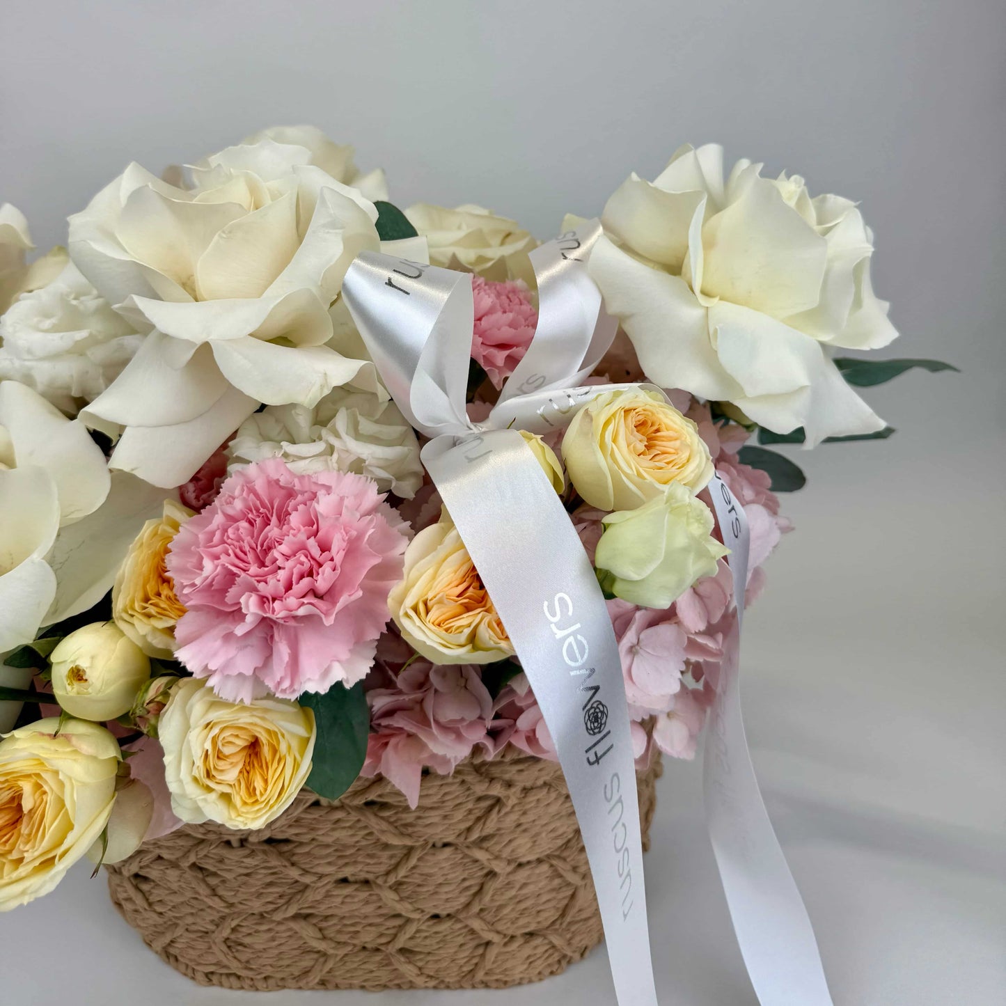 Close-up of flower basket arrangement with roses and hydrangeas
