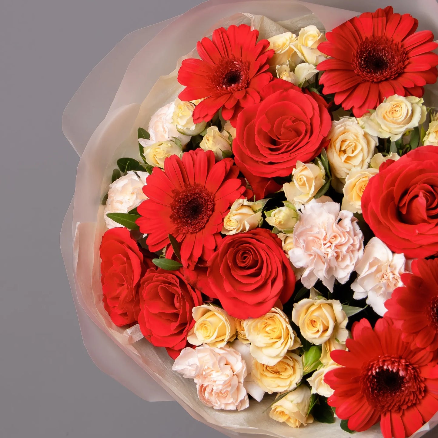 Close-up of gerbera and roses in vibrant bouquet