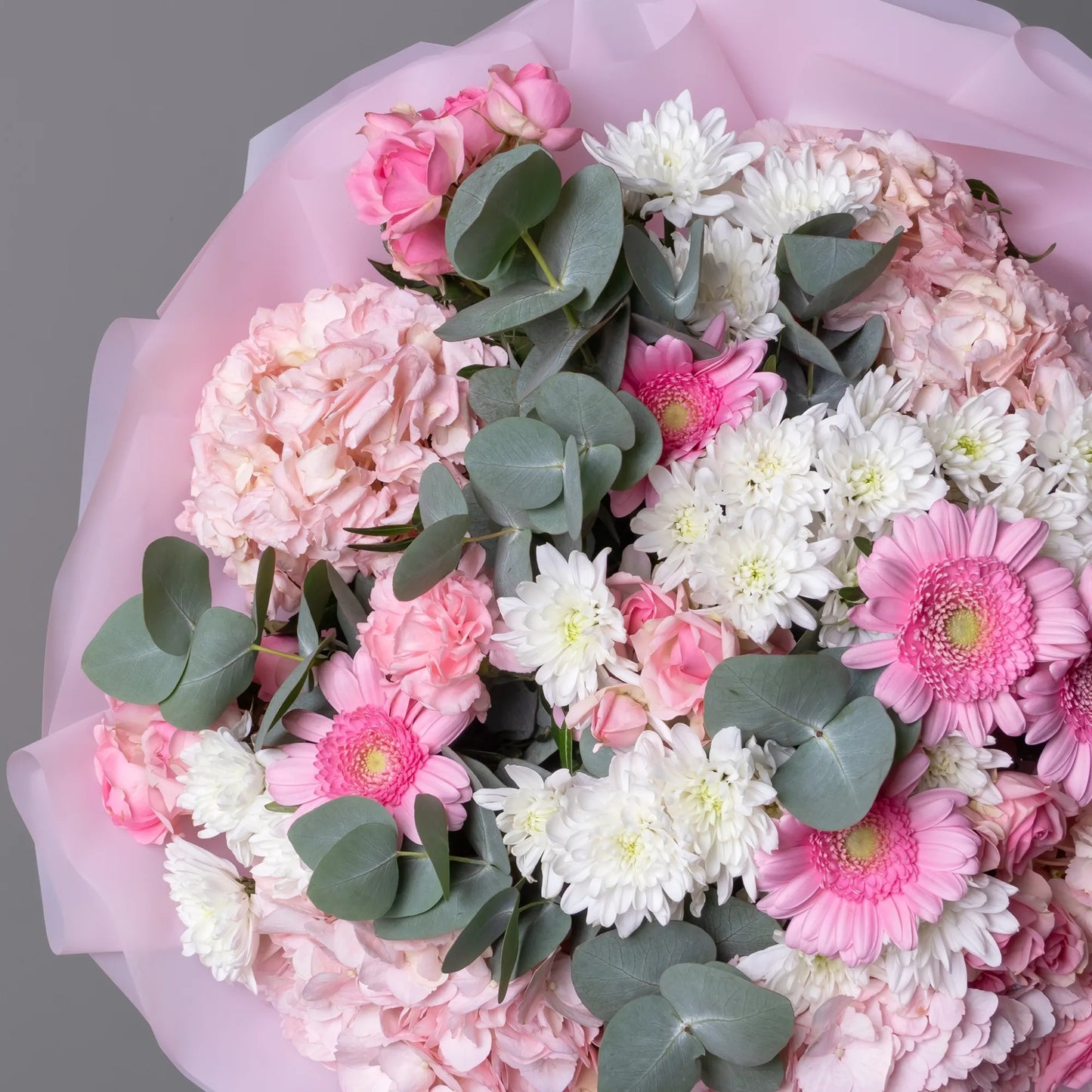Close-up of hydrangea, spray roses, and pastel blooms in soft bouquet