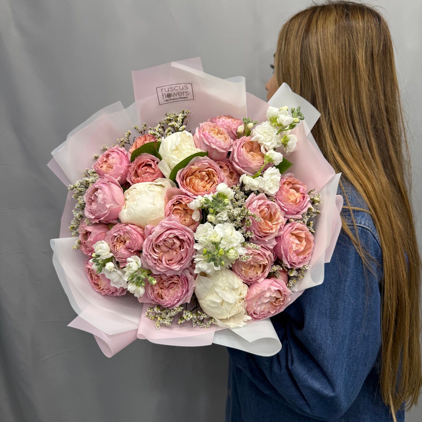 Peach Juliet roses, pink peonies, and greenery in a romantic bouquet
