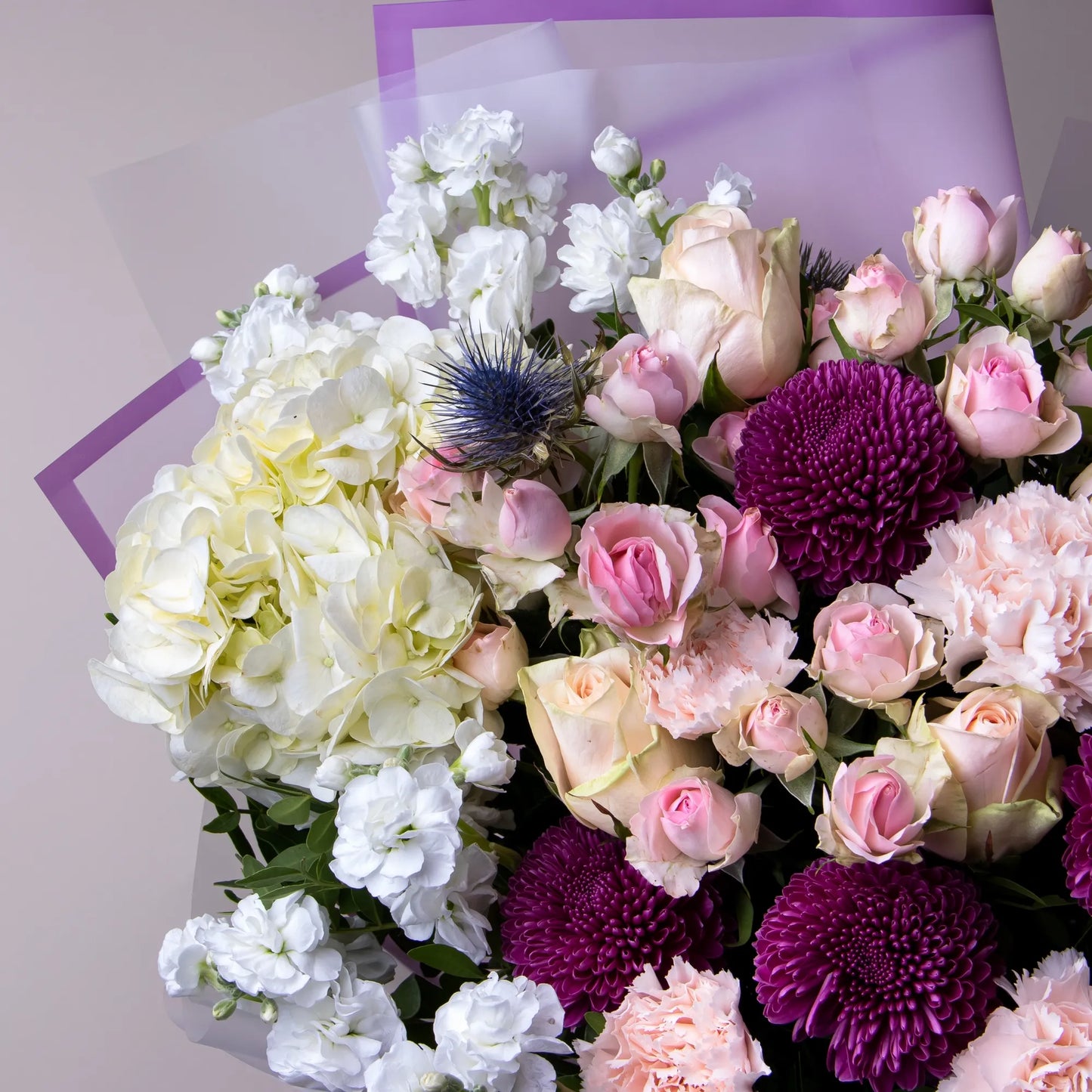 Close-up of roses, spray roses, and hydrangea in vibrant floral mix