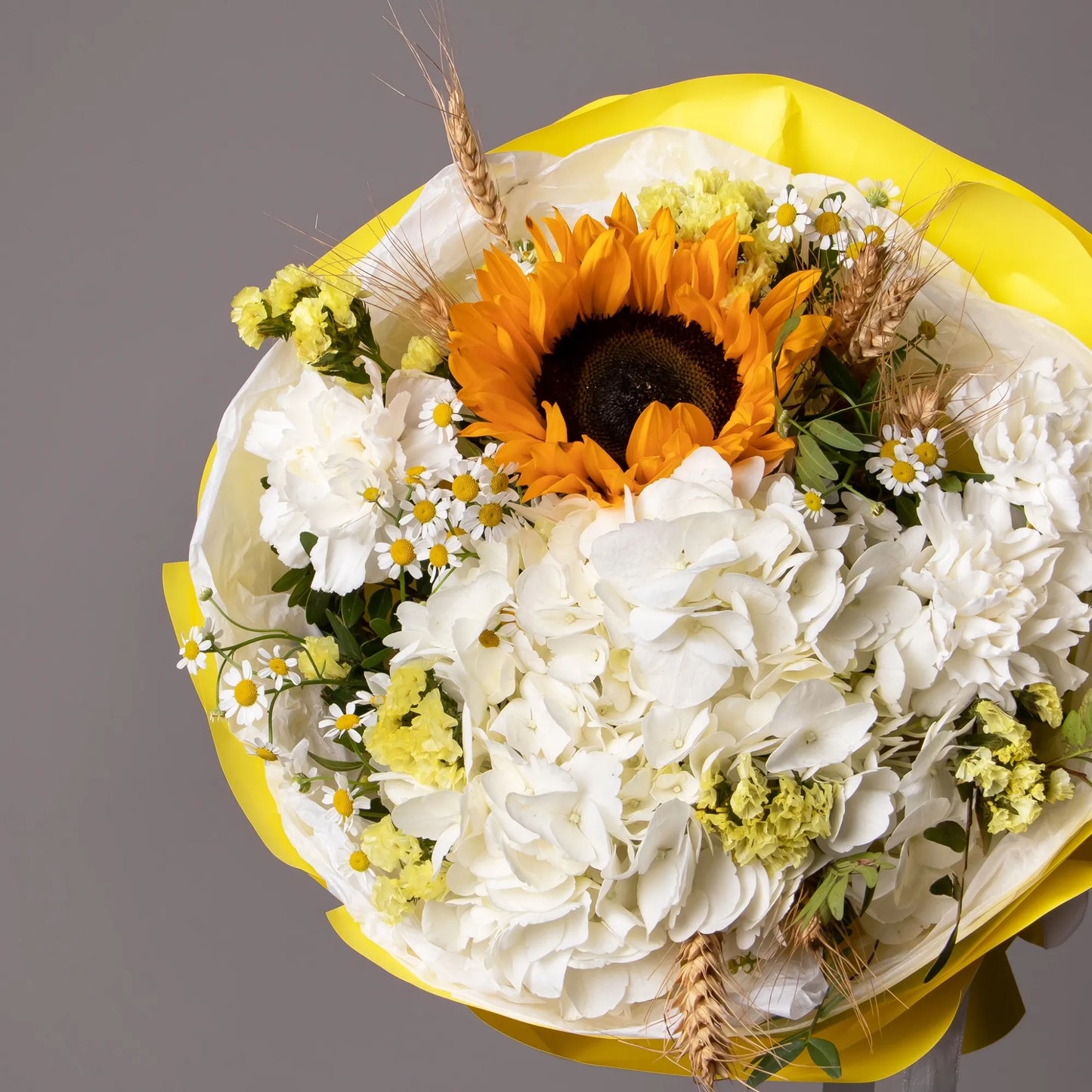 Close-up of sunflower and chamomile in cheerful summer bouquet