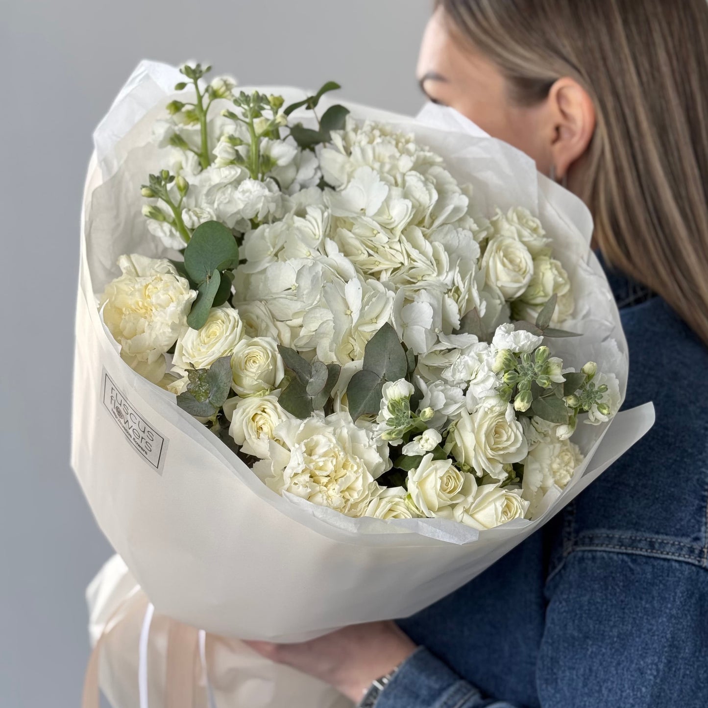 White bouquet with hydrangeas, carnations, spray roses, and stock