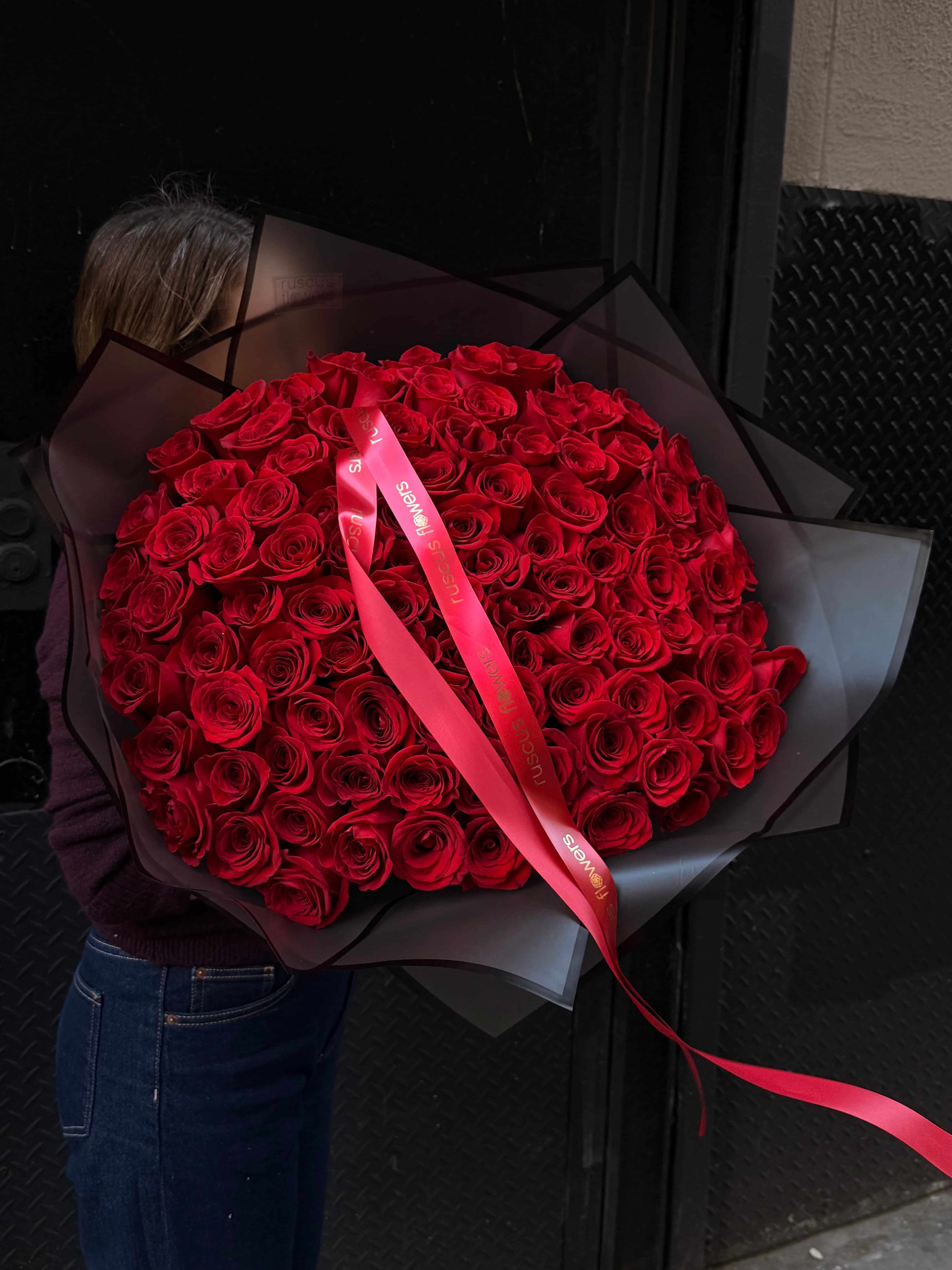 100 red roses in bold black wrapping