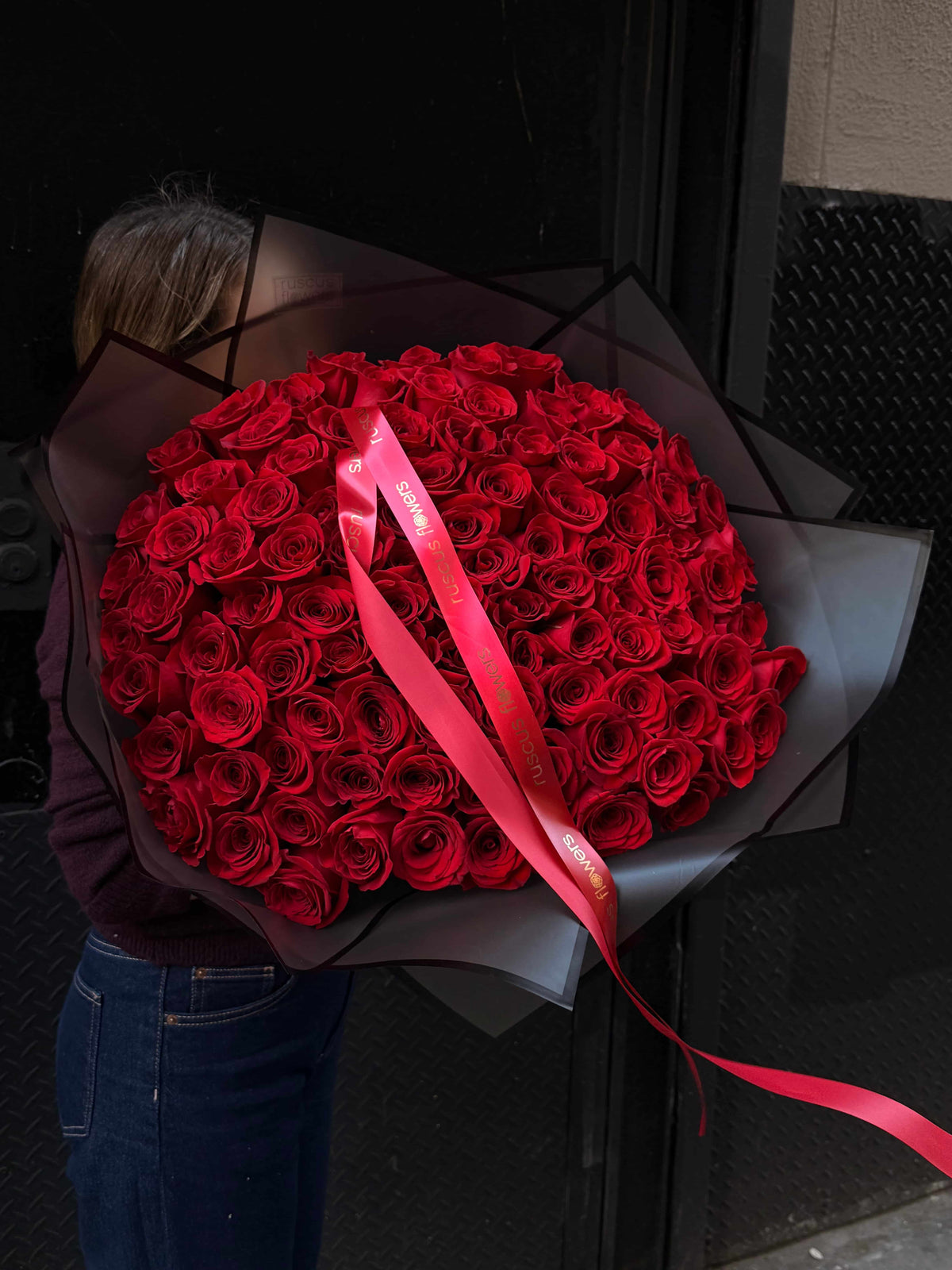 100 red roses in bold black wrapping