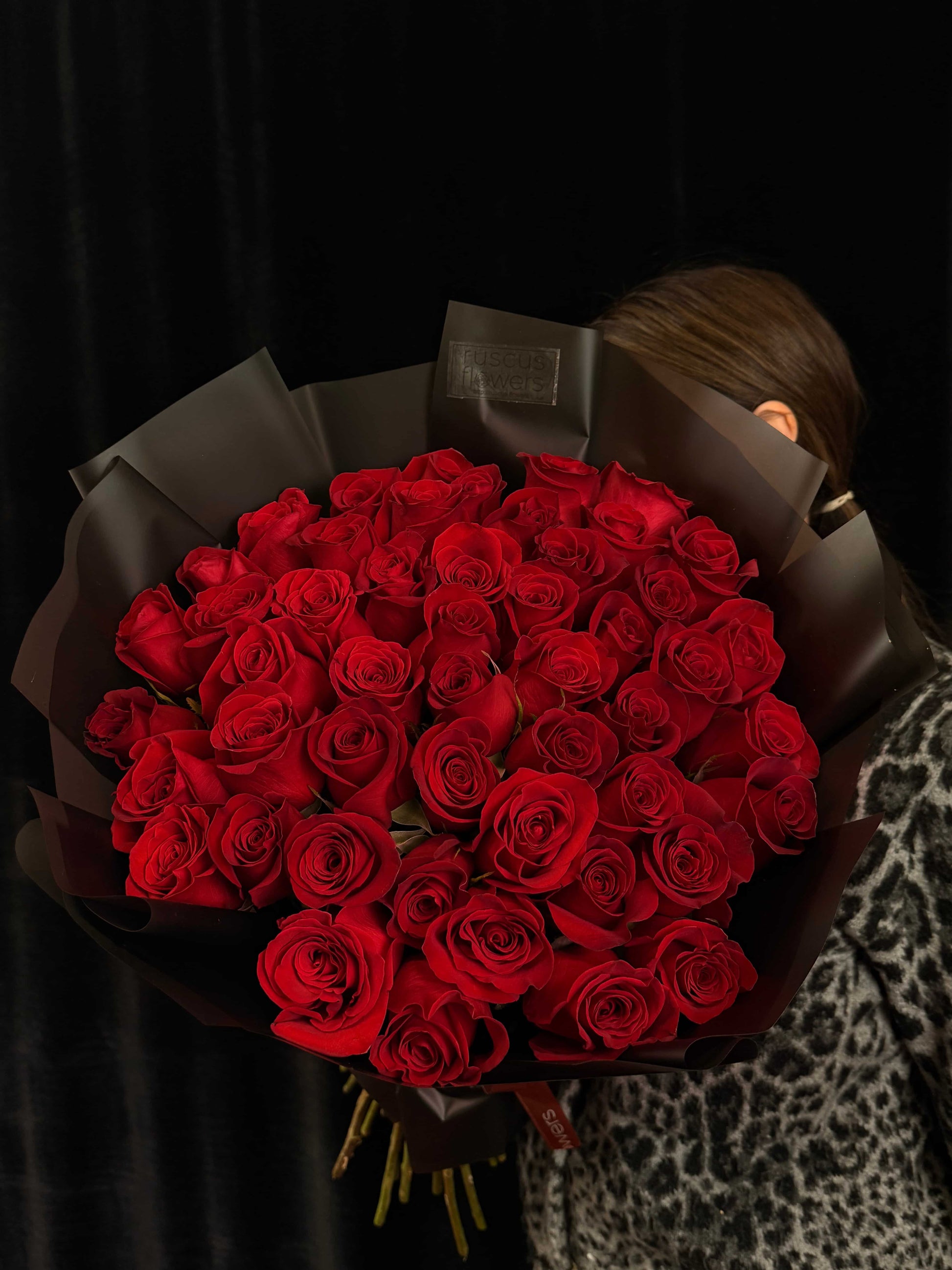 50 red roses in black wrapping