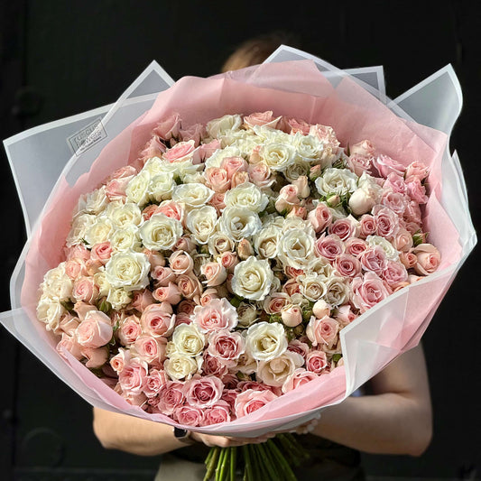 Hand-tied bouquet of 55 clustered spray roses.