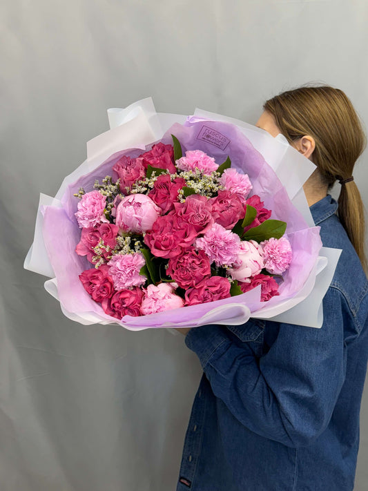 Colorful bouquet with roses, peonies, carnations, and seasonal greenery