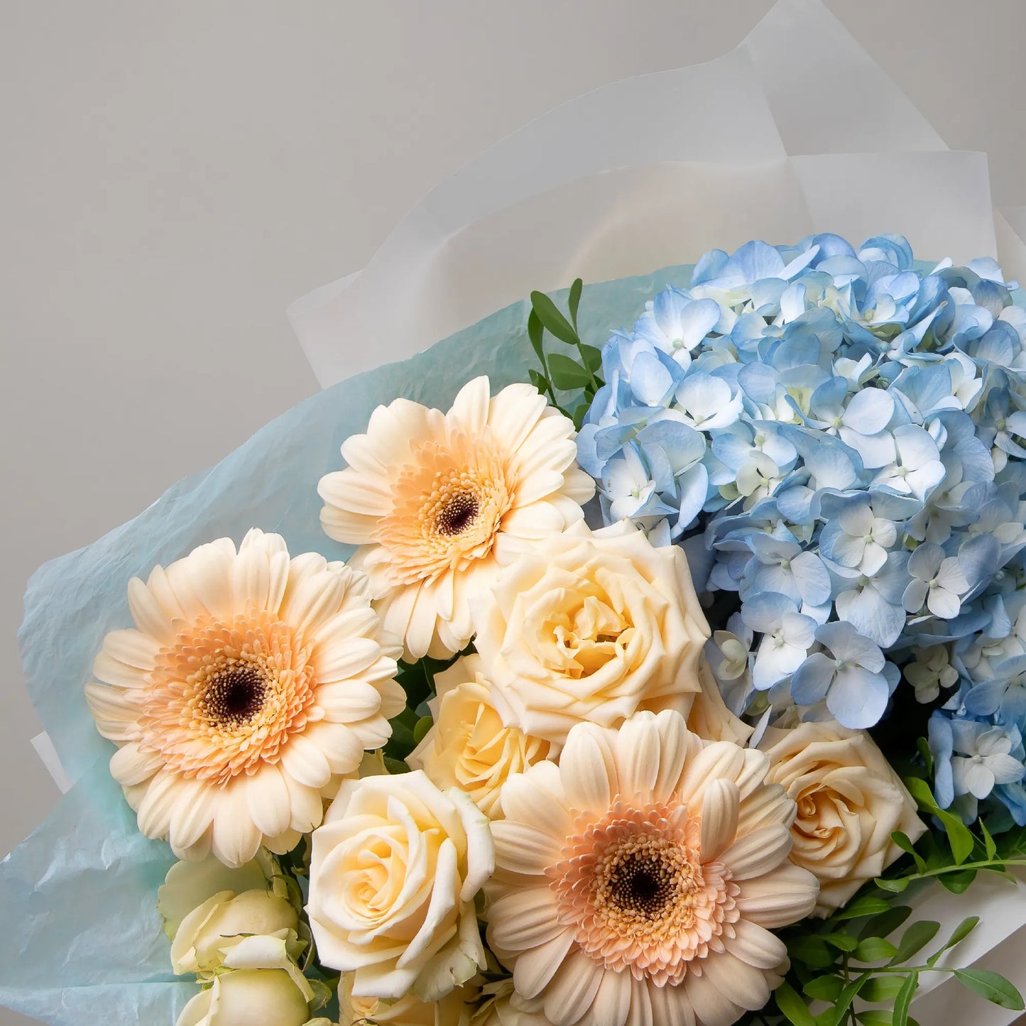 Close-up of hydrangea, gerbera, and spray roses in soft bouquet