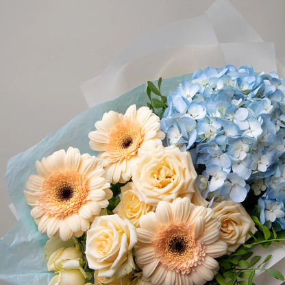 Close-up of hydrangea, gerbera, and spray roses in soft bouquet