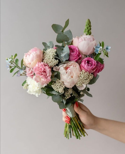 Soft bridal bouquet with peonies, spray roses, ozothamnus, and blue oxypetalum.