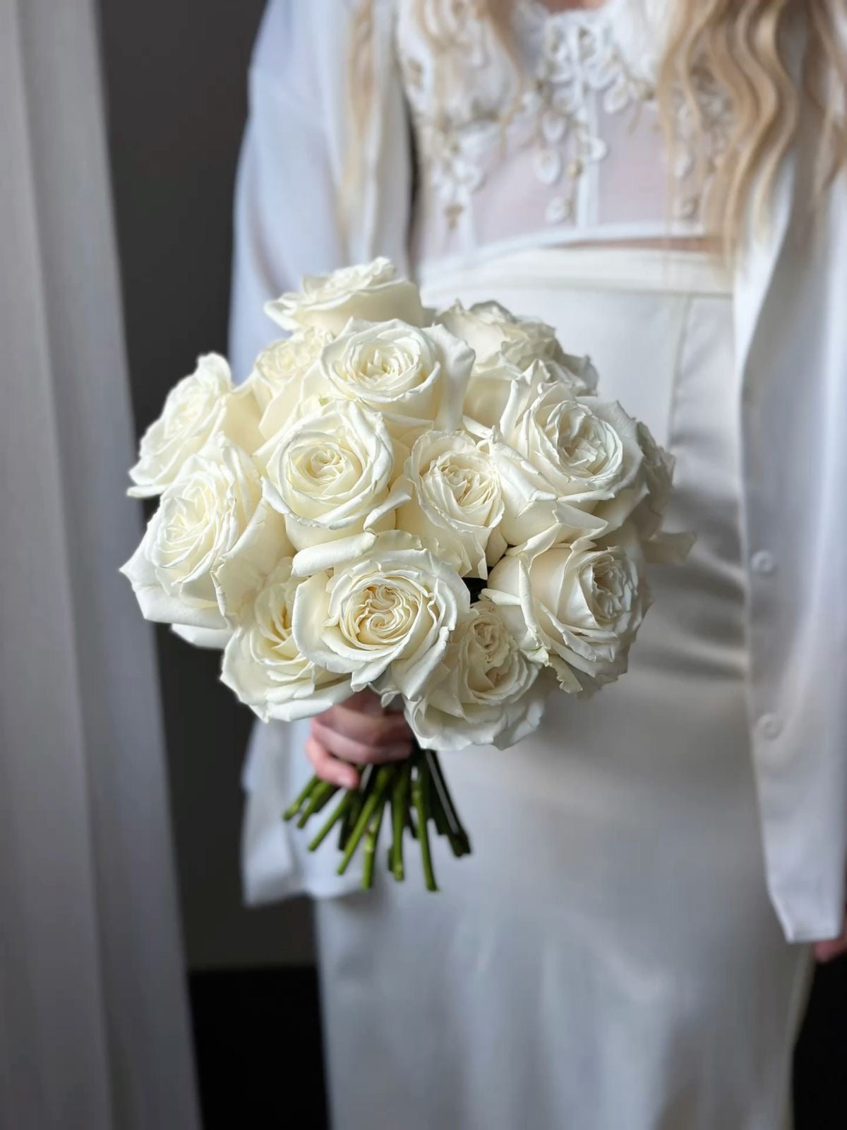 Classic white bridal bouquet made of fresh roses.