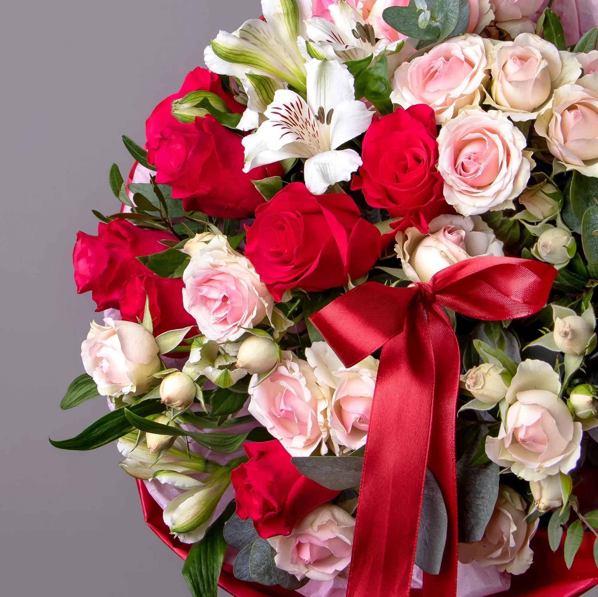 Close-up of bright roses and spray roses in floral arrangement