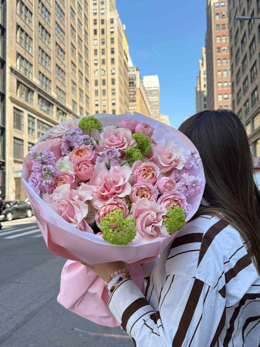 Bouquet with French roses, hydrangeas and viburnum in soft pastel wrapping