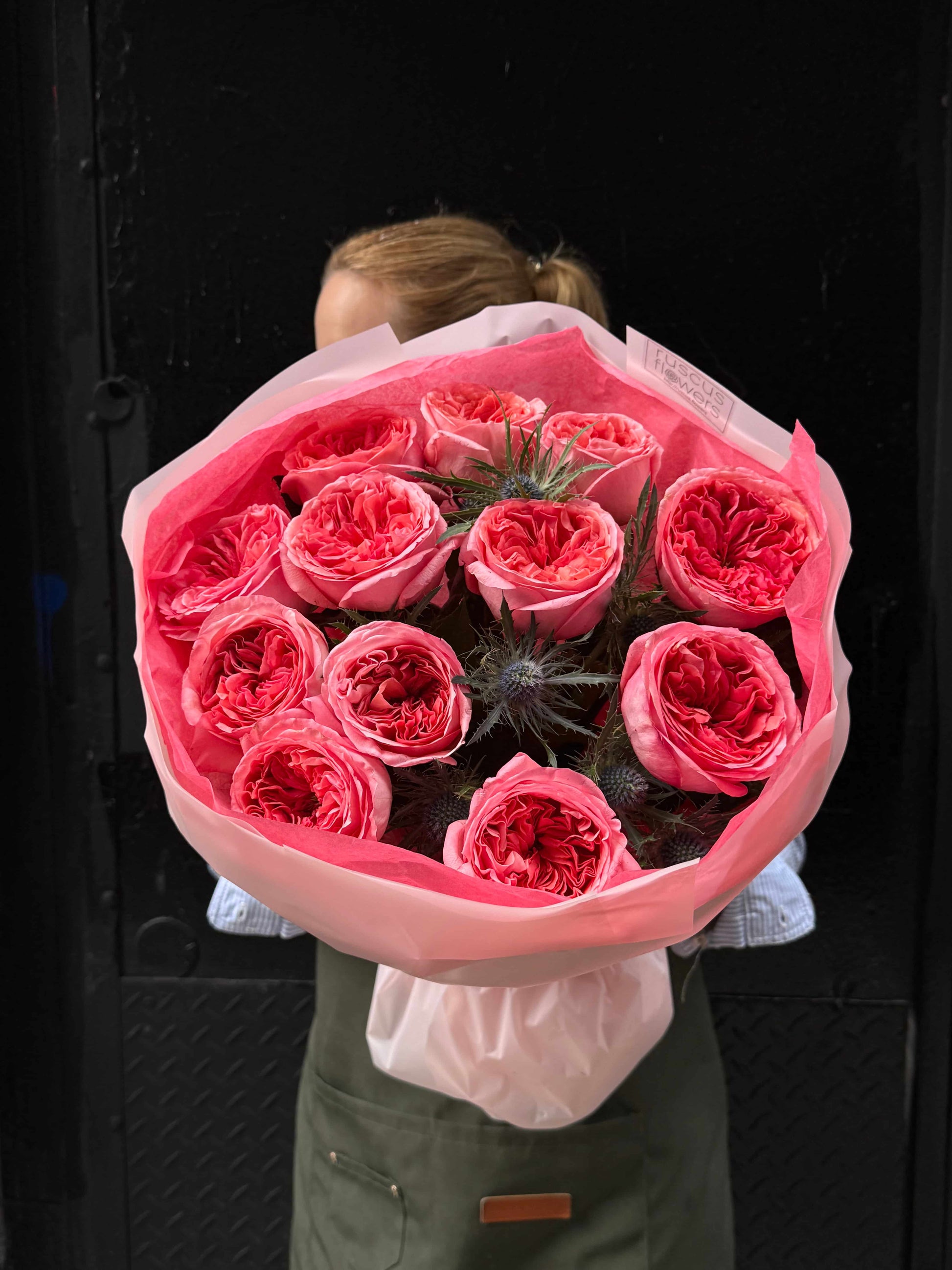 Bouquet of garden roses with blue eryngium in elegant wrapping