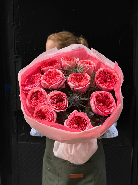 Bouquet of garden roses with blue eryngium in elegant wrapping