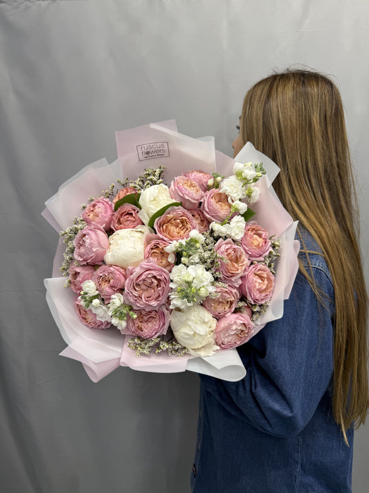 Peach Juliet roses, pink peonies, and greenery in a romantic bouquet
