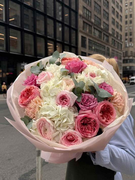 Garden bouquet with hydrangea, roses and ranunculus in soft blush wrapping