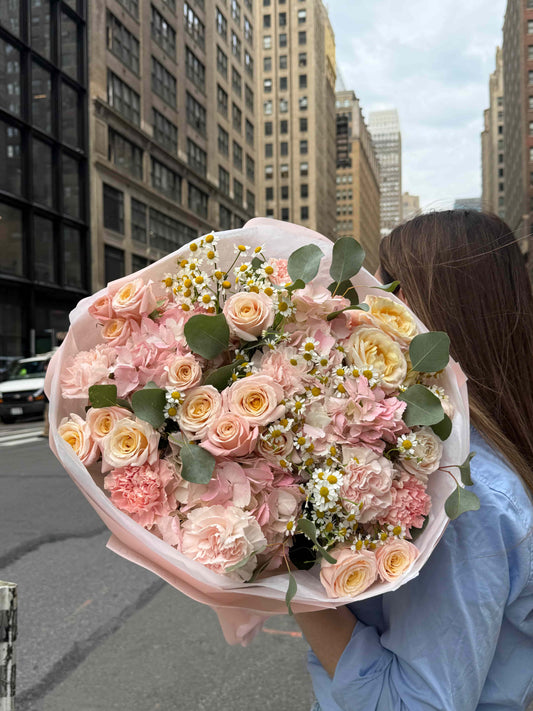 Bouquet with hydrangeas, spray garden roses and daisies in pastel wrapping