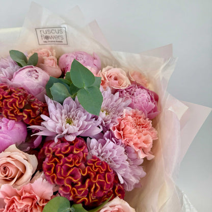Close-up of soft peonies and dark celosia in elegant bouquet