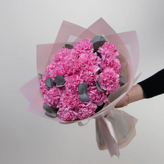 Bouquet of pink carnations with eucalyptus and pistachio leaves