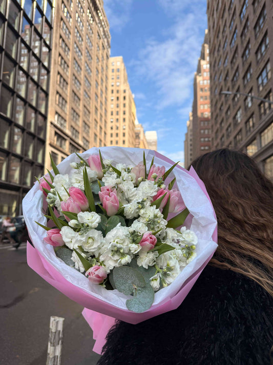 Pink tulips and white stock bouquet wrapped in pastel paper in NYC