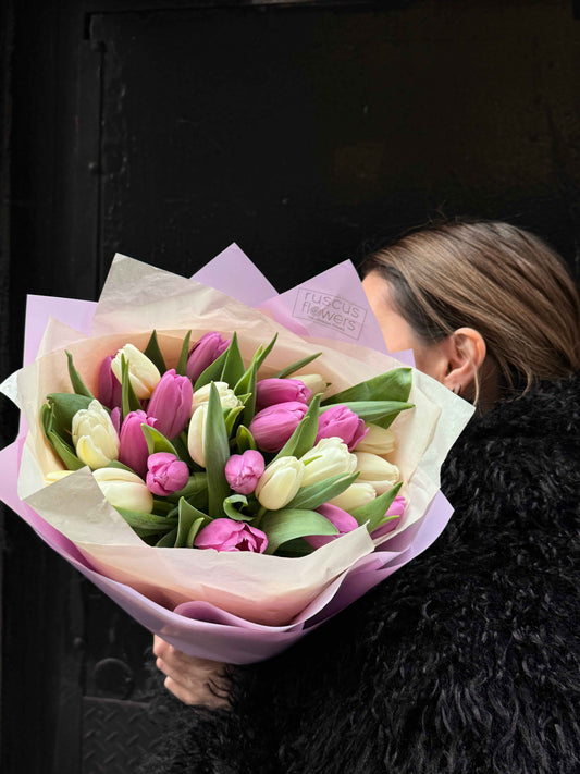 Bouquet with pink and white tulips wrapped in soft pastel paper
