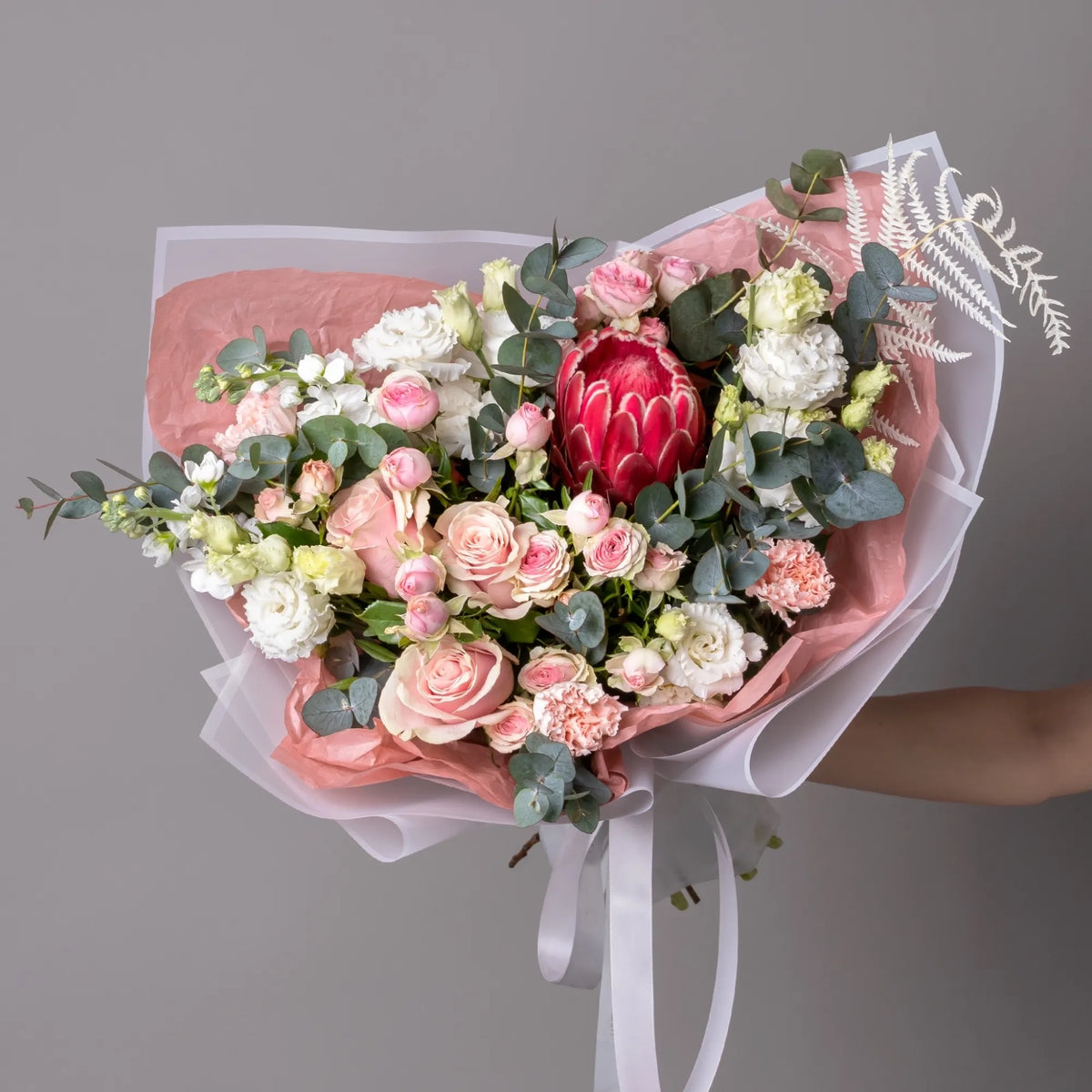 Bouquet with protea, roses, lisianthus, carnations, and stock