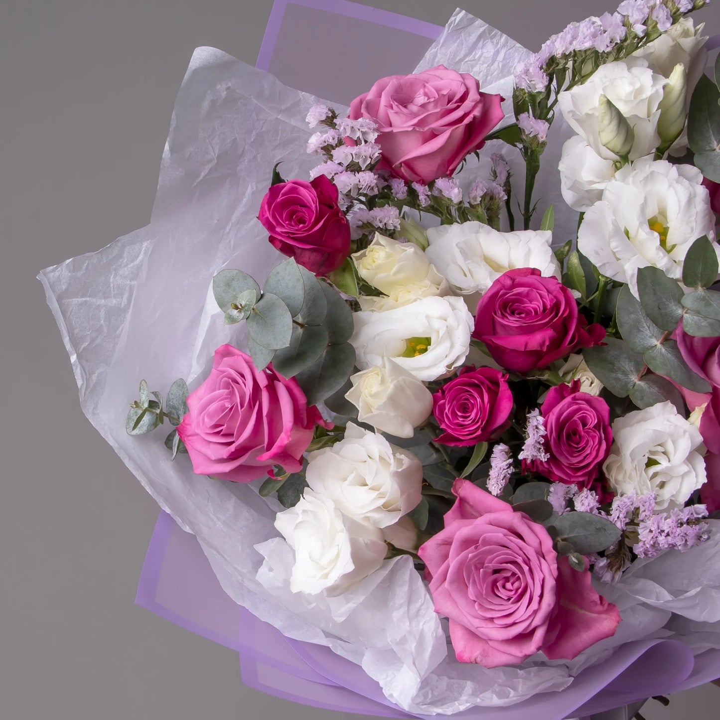 Close-up of purple roses and lisianthus in elegant bouquet