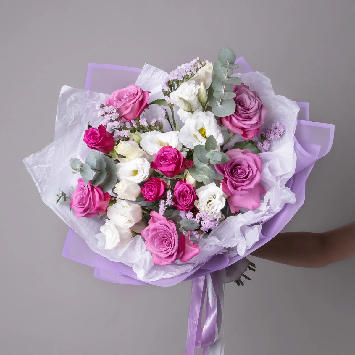 Bouquet with purple roses, white lisianthus, eucalyptus, and greenery