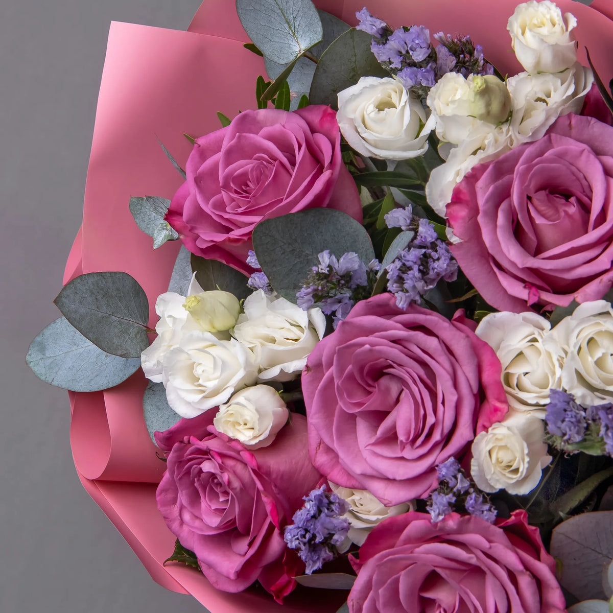 Close-up of purple roses and white lisianthus in elegant bouquet