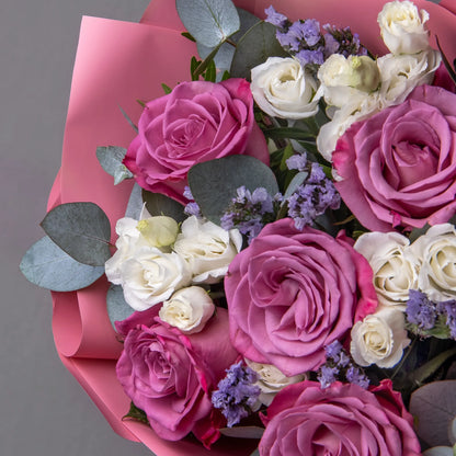 Close-up of purple roses and white lisianthus in elegant bouquet