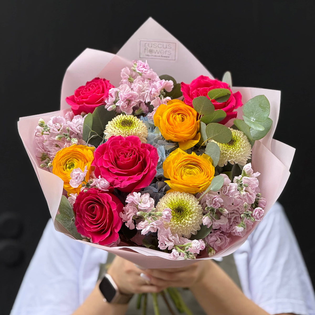 Hand-tied bouquet with ranunculus, roses, hydrangea, stock, chrysanthemums and eucalyptus.