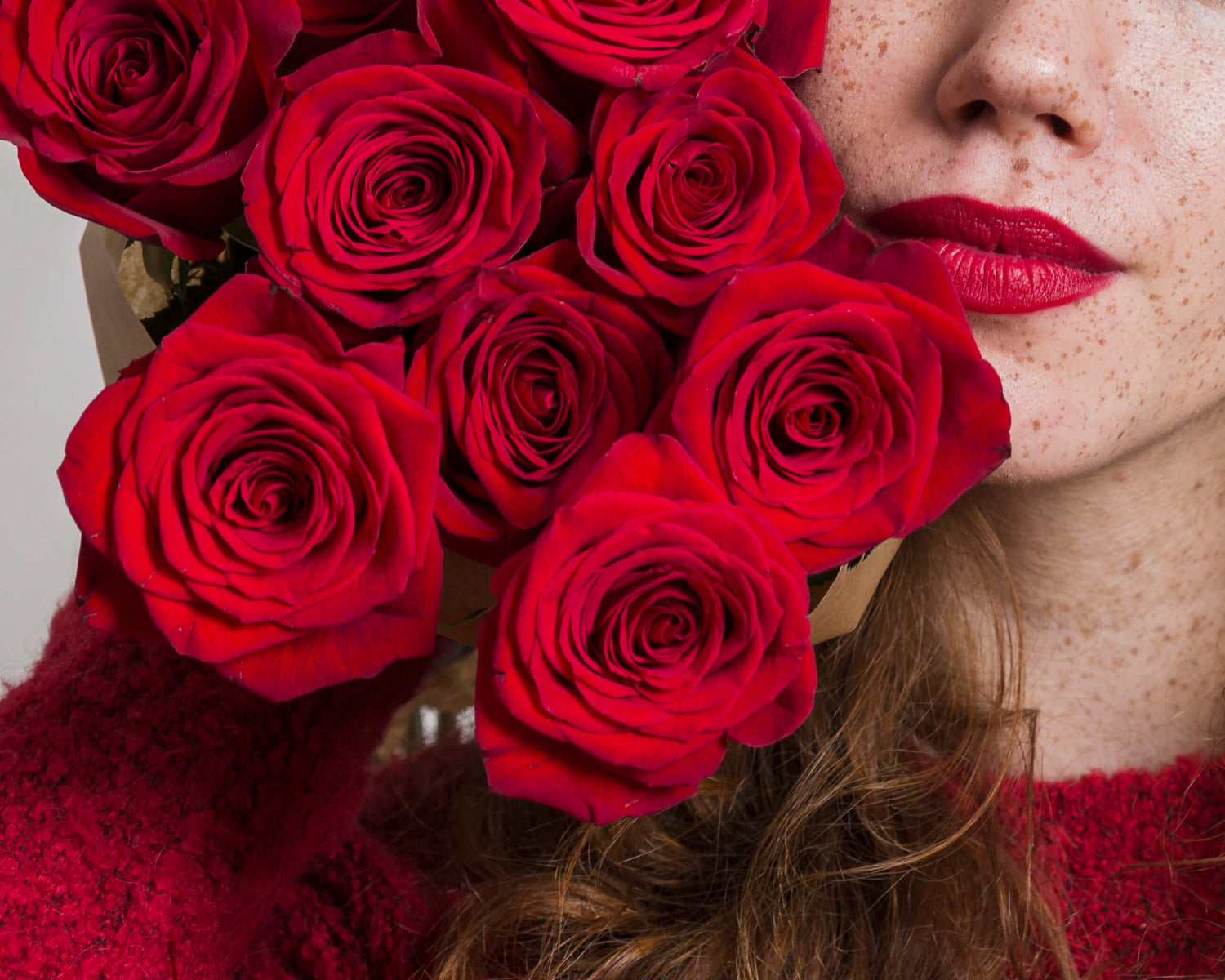 Woman holding a bouquet of red roses – same-day flower delivery in NYC