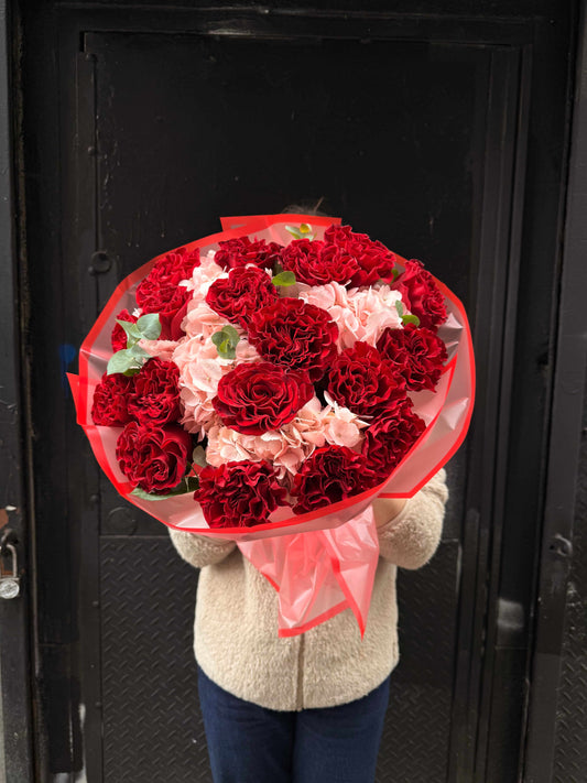 Bouquet with pink roses and hydrangeas in soft wrapping