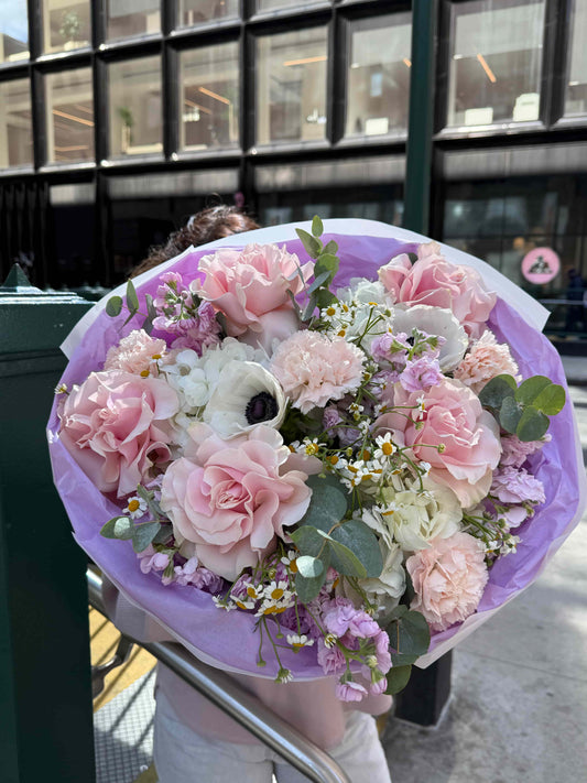 Bouquet with hydrangea, French roses and anemones in soft pastel wrapping