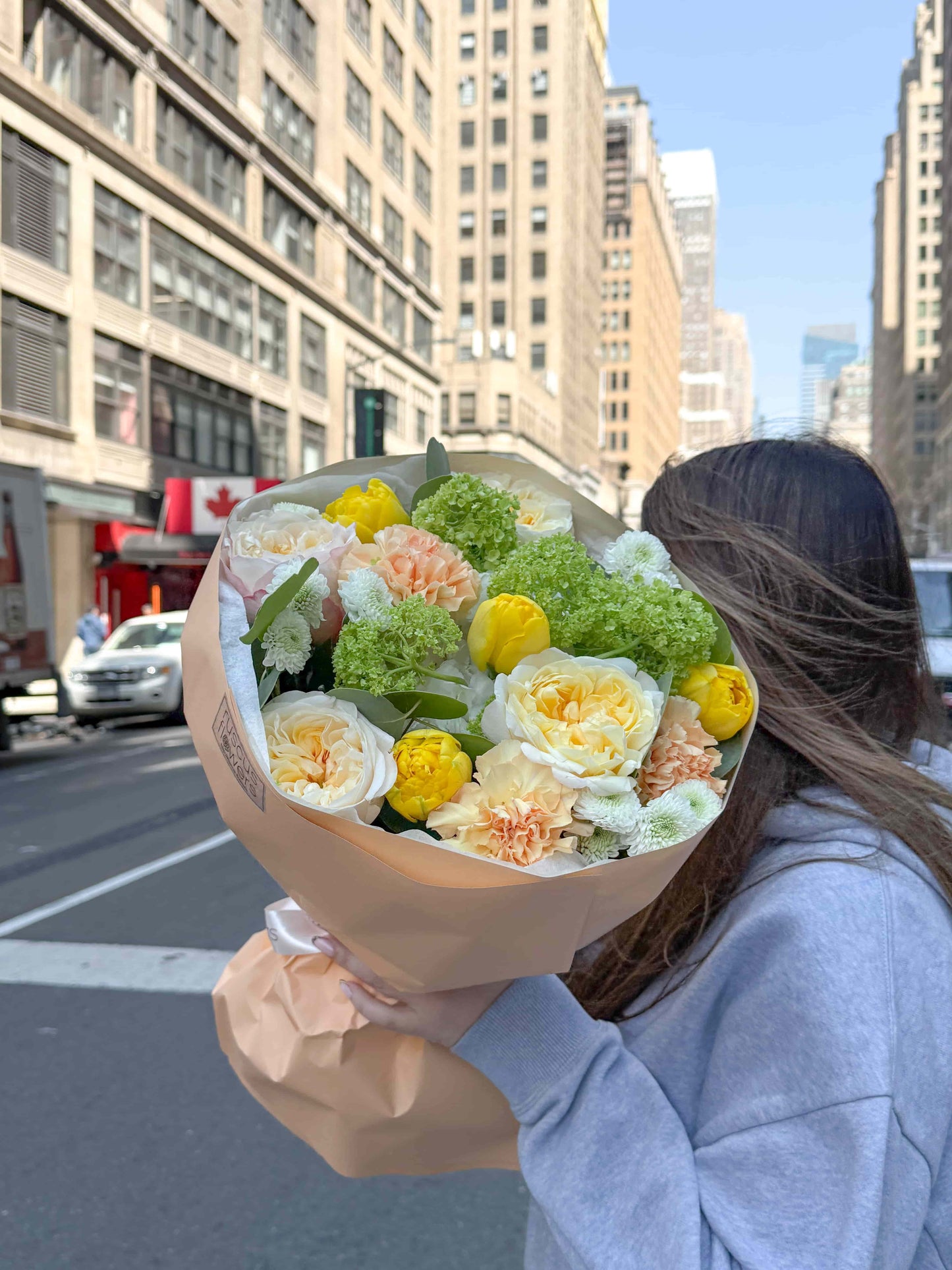 Bouquet with garden roses, hydrangea and peony tulips in soft wrapping
