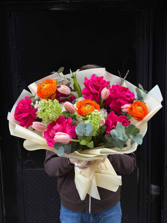 Spring bouquet with roses, ranunculus, tulips and hydrangea in soft pastel wrapping