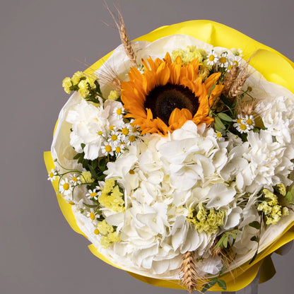 Close-up of sunflower and chamomile in cheerful summer bouquet