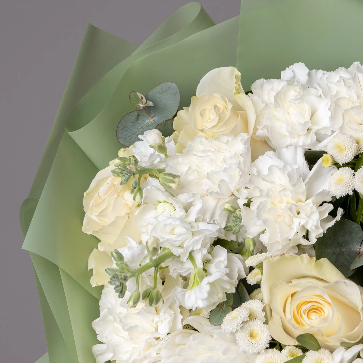 Close-up of white stock and roses in elegant floral mix