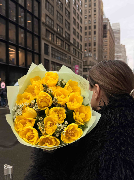 Yellow peony tulip bouquet with wax flowers wrapped in soft paper